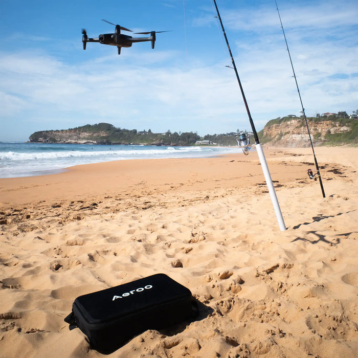 Aeroo Pro Drone flying over beach with fishing rods and carry case