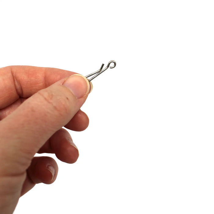 Hand holding a Gemini Genie Rig System link clip on a white background