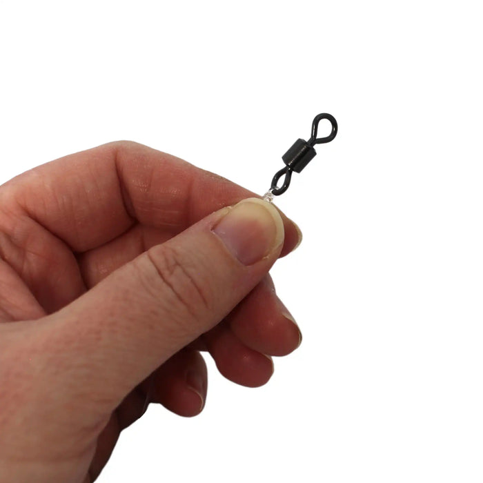 A close-up of a hand holding a small black swivel clasp with a clear rubber grommet against a plain white background.