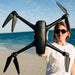 Woman holding Aeroo pro Drone with beach in background
